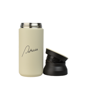 A cream coloured Kinto 350ml Tumbler with the Patricia logo printed in black on the front. The two-part lid has been removed and is sitting next to it.