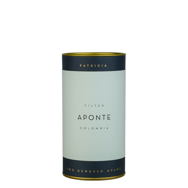 A navy blue cylinder with a light blue label describes the roasted coffee beans within. 'PATRICIA' and 'TWO HUNDRED GRAMS' are printed in gold foil.