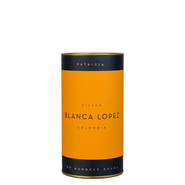 A navy blue cylinder with an orange label describes the roasted coffee beans within. 'PATRICIA' and 'TWO HUNDRED GRAMS' are printed in gold foil.