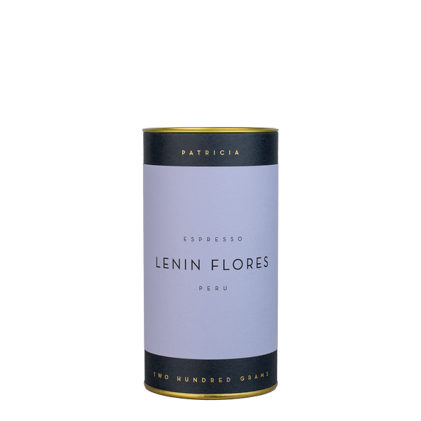 A navy blue cylinder with a purple label describes the roasted coffee beans within. 'PATRICIA' and 'TWO HUNDRED GRAMS' are printed in gold foil.
