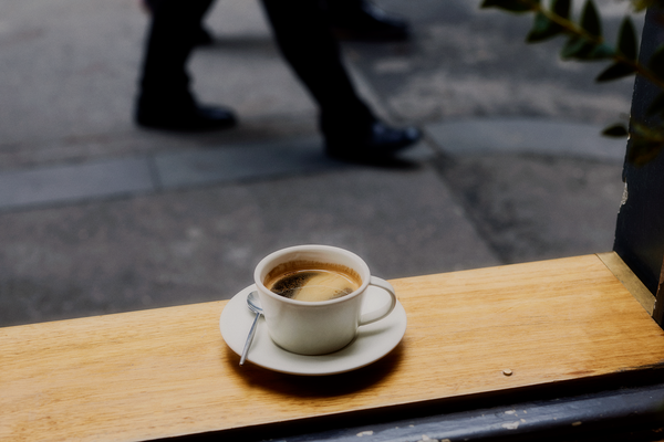A long black sits on the wooden window sill at Patricia. A customer's feet can be seen in the background.