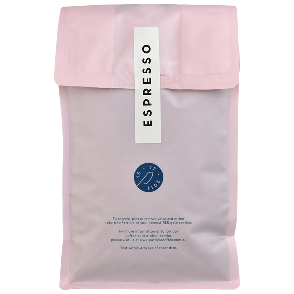 The back of a light pink bag with the containing 1kg of specialty coffee beans roasted for espresso.