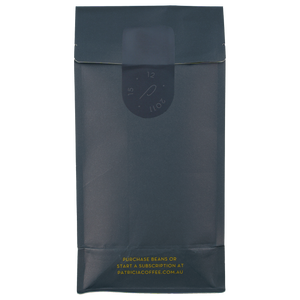 Dark blue coffee bag with gold text and an embossed sticker showing the birthday of Patricia Coffee Brewers