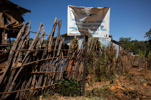 A white sign for Hadeso Washing Station in front of a wooden fence against a clear blue sky