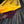 Natural processing of coffee cherries under a yellow tarp.