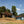 Ayla Washing Station sits on a hillside with trees and blue sky. The buildings are painted white and sky-blue.