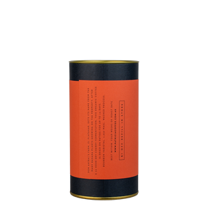 A navy blue cylinder with an red label describes the roasted coffee beans within.