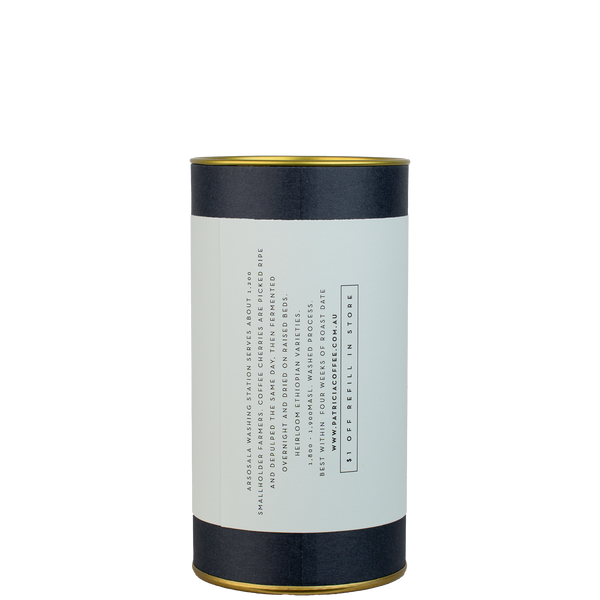 A navy blue cylinder with a colour label describes the roasted coffee beans within.