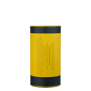 A navy blue cylinder with a yellow label describes the roasted coffee beans within.