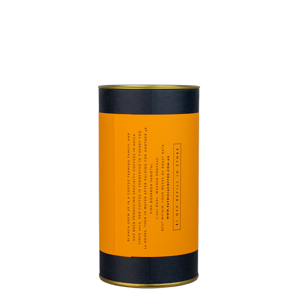 A navy blue cylinder with an orange label describes the roasted coffee beans within.