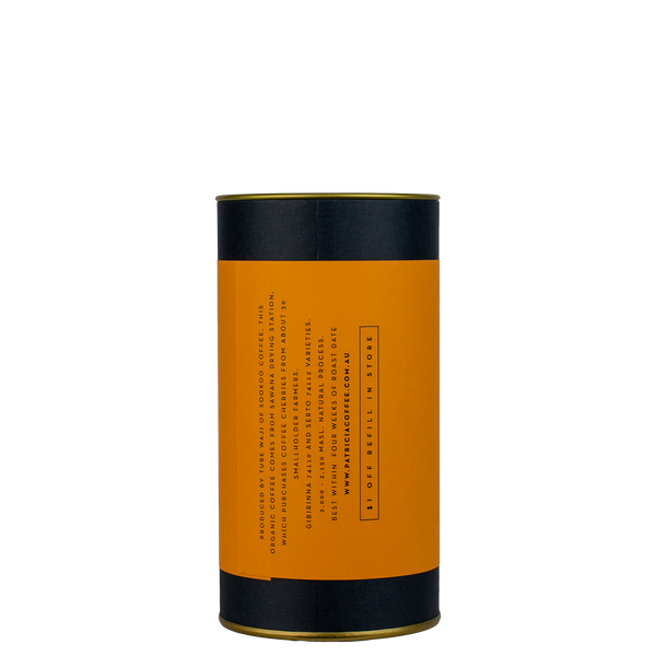 A navy blue cylinder with an orange label describes the filter coffee beans within.