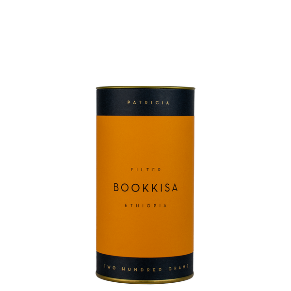 A navy blue cylinder with an orange label describes the filter coffee beans within. 'PATRICIA' and 'TWO HUNDRED GRAMS' are printed in gold foil.