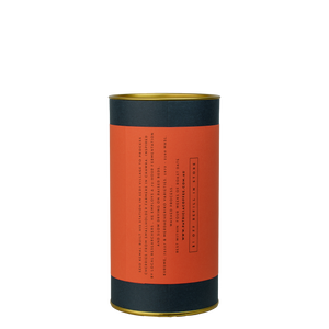 A navy blue cylinder with a red label describes the roasted coffee beans within.