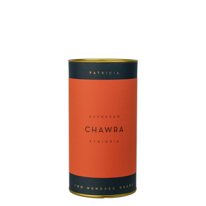 A navy blue cylinder with a red label describes the roasted coffee beans within. 'PATRICIA' and 'TWO HUNDRED GRAMS' are printed in gold foil.