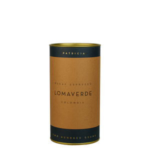 Dark blue cylinder with gold writing, and a brown label describing the decaf espresso coffee beans within.