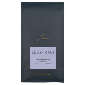 A navy blue recyclable bag containing 1kg of specialty coffee beans. It has the Patricia logo in gold, the coffee's name on a light purple sticker, and 'One kilogram' in gold underneath.