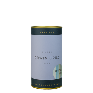 A navy blue cylinder with a lilac label describes the roasted coffee beans within. 'PATRICIA' and 'TWO HUNDRED GRAMS' are printed in gold foil. A shiny round sticker reads 'SPECIAL LOT'