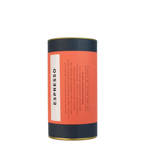 A navy blue cylinder with a red label describes the espresso coffee beans within.