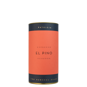 A navy blue cylinder with a red label describes the espresso coffee beans within. 'PATRICIA' and 'TWO HUNDRED GRAMS' are printed in gold foil.