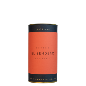 A navy blue cylinder with a red label describes the espresso coffee beans within. 'PATRICIA' and 'TWO HUNDRED GRAMS' are printed in gold foil.