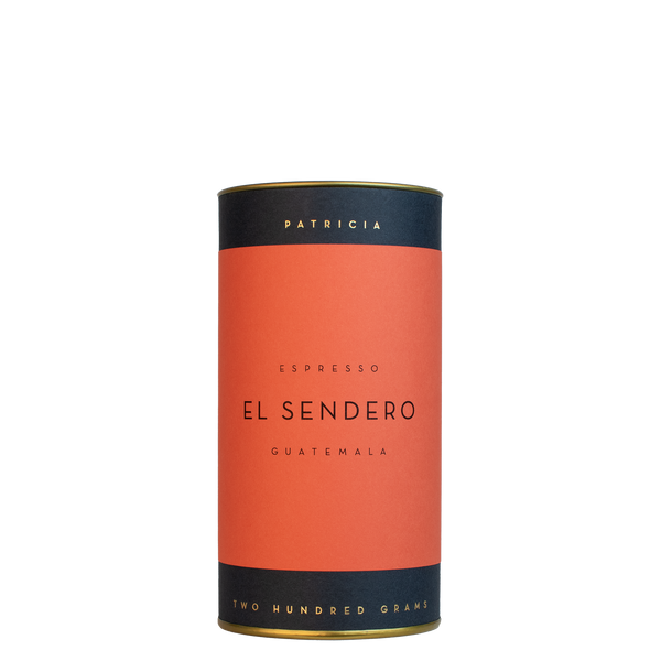 A navy blue cylinder with a red label describes the espresso coffee beans within. 'PATRICIA' and 'TWO HUNDRED GRAMS' are printed in gold foil.