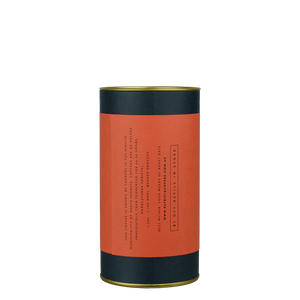 A navy blue cylinder with a red label describes the roasted coffee beans within.