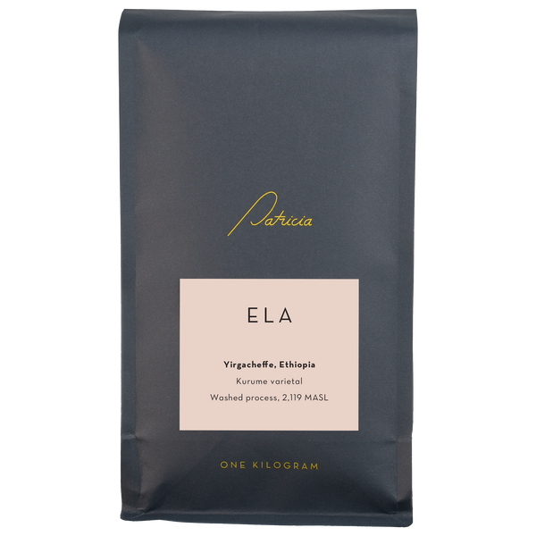 A navy blue recyclable bag containing 1kg of specialty coffee beans. It has the Patricia logo in gold, the coffee's name on a pink sticker, and 'One kilogram' in gold underneath.