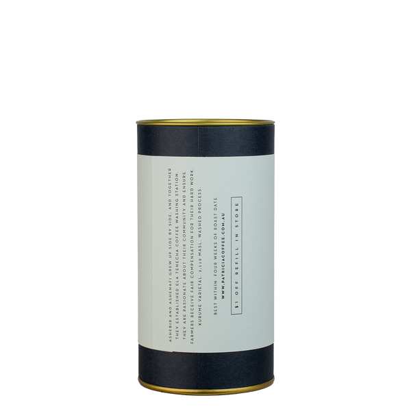 A navy blue cylinder with a light blue label describes the roasted coffee beans within.