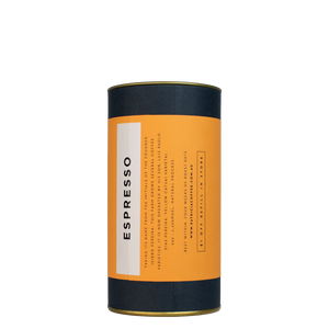 A navy blue cylinder with a orange label describes the espresso coffee beans within.