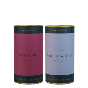 A plum coloured tin of Kikai PB sits next to a lilac coloured tin of San Sebastian.