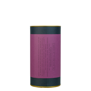 A navy blue cylinder with a purple label describes the roasted coffee beans within.