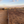 A long outdoor drying bed covered with coffee beans, on farmland under a blue sky.