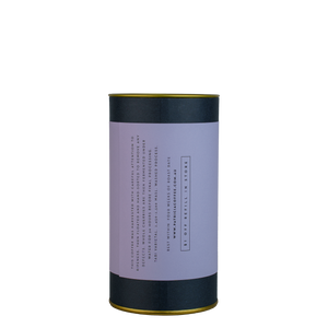 A navy blue cylinder with a purple label describes the roasted coffee beans within.