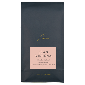 A navy blue recyclable bag containing 1kg of specialty coffee beans. It has the Patricia logo in gold, the coffee's name on a pink sticker, and 'One kilogram' in gold underneath.