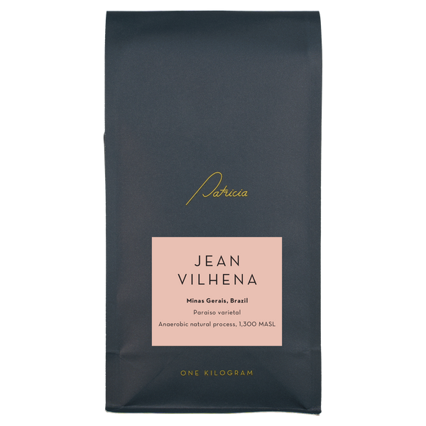 A navy blue recyclable bag containing 1kg of specialty coffee beans. It has the Patricia logo in gold, the coffee's name on a pink sticker, and 'One kilogram' in gold underneath.