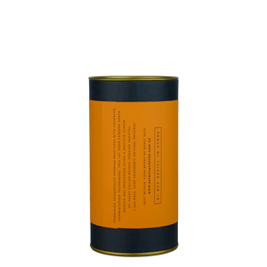 A navy blue cylinder with an orange label describes the roasted coffee beans within.