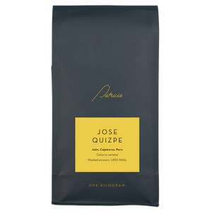 A navy blue recyclable bag containing 1kg of specialty coffee beans. It has the Patricia logo in gold, the coffee's name on a yellow sticker, and 'One kilogram' in gold underneath.