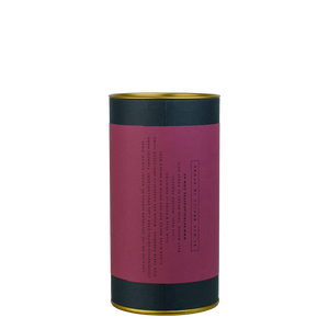 A navy blue cylinder with a purple label describes the roasted coffee beans within.
