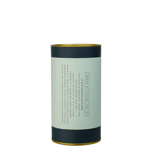A navy blue cylinder with a light blue label describes the roasted coffee beans within.