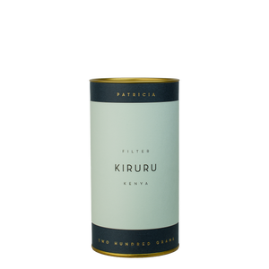 A navy blue cylinder with a light blue label describes the roasted coffee beans within. 'PATRICIA' and 'TWO HUNDRED GRAMS' are printed in gold foil.