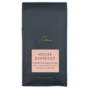 Dark blue coffee bag with 'Patricia' branding and 'House Espresso' label on a pink background