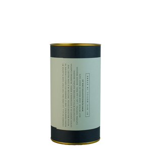 A navy blue cylinder with a light blue label describes the roasted coffee beans within.