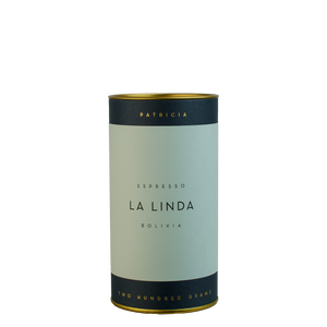 A navy blue cylinder with a light blue label describes the roasted coffee beans within. 'PATRICIA' and 'TWO HUNDRED GRAMS' are printed in gold foil.