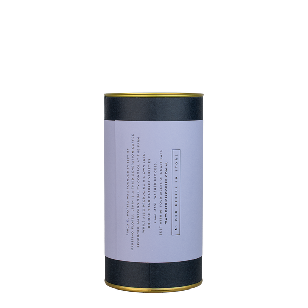 A navy blue cylinder with a purple label describes the roasted coffee beans within.