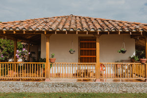 The Lomaverde homestead, with hanging plants and wooden railing.