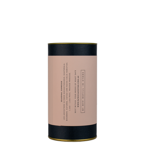 A navy blue cylinder with a pink label describes the espresso coffee beans within.