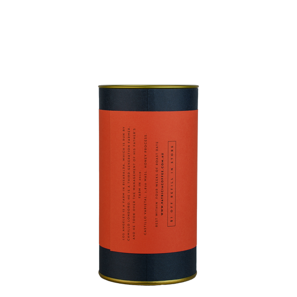 A navy blue cylinder with a red label describes the roasted coffee beans within.