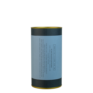 A navy blue cylinder with a blue label describes the roasted coffee beans within.