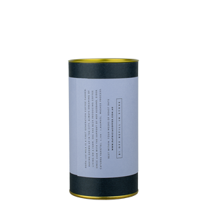 A navy blue cylinder with an lilac label describes the roasted coffee beans within.