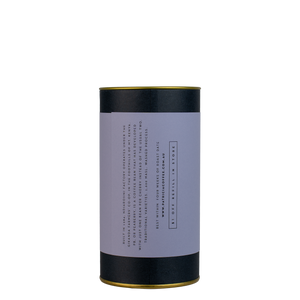 A navy blue cylinder with a purple label describes the roasted coffee beans within.